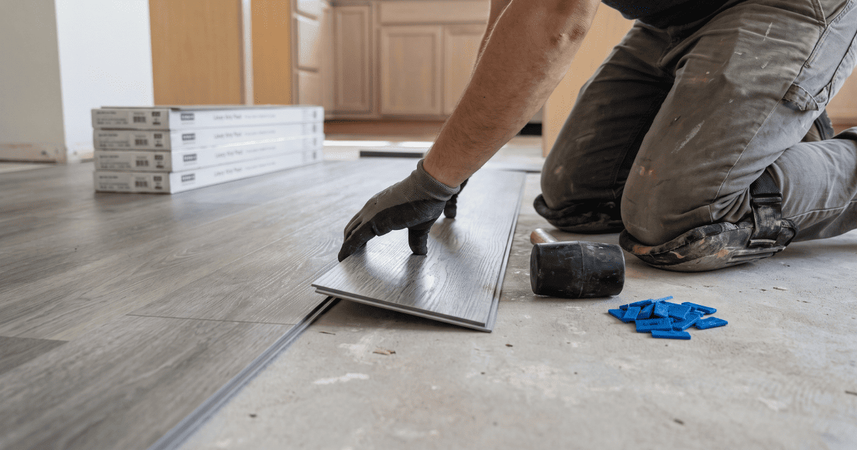 Installer laying luxury vinyl plank flooring in a Snellville kitchen